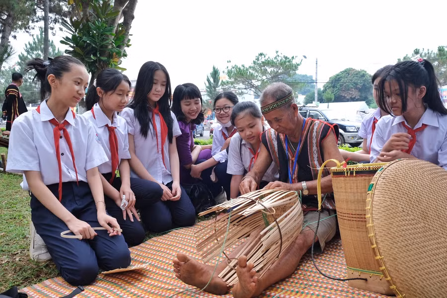 Học sinh trường THCS Nguyễn Du (TP. Pleiku) thích thú xem nghệ nhân đan lát, làm ra các sản phẩm từ mây, tre. Ảnh: Hoàng Ngọc
