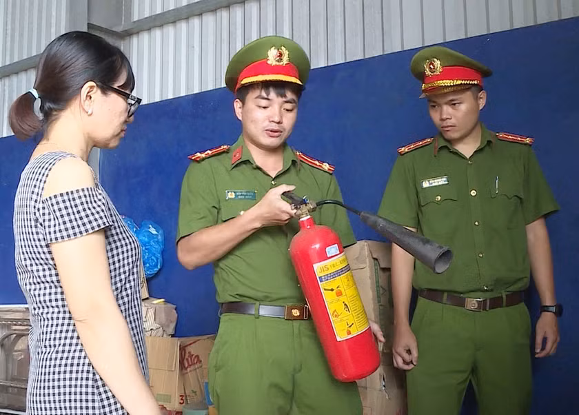 Cán bộ Phòng Cảnh sát Phòng cháy chữa cháy và Cứu nạn cứu hộ (Công an tỉnh) hướng dẫn người dân sử dụng bình chữa cháy. Ảnh: T.D