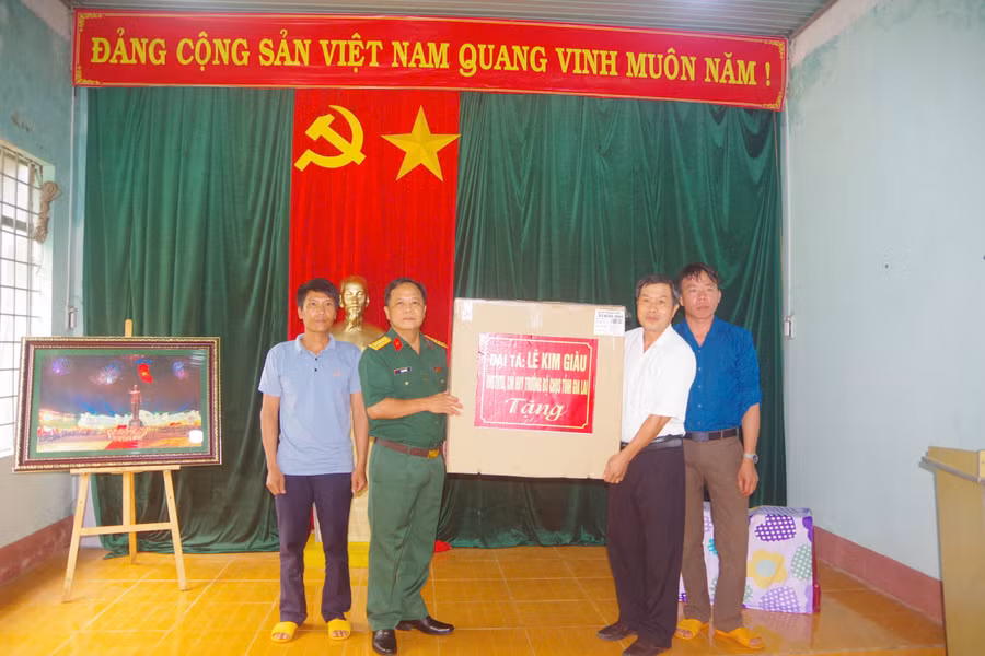 Dịp này, Đại tá Lê Kim Giàu tặng phần quà cho cán bộ và nhân dân thôn Cửa Khẩu. Ảnh: Thanh Tuyền