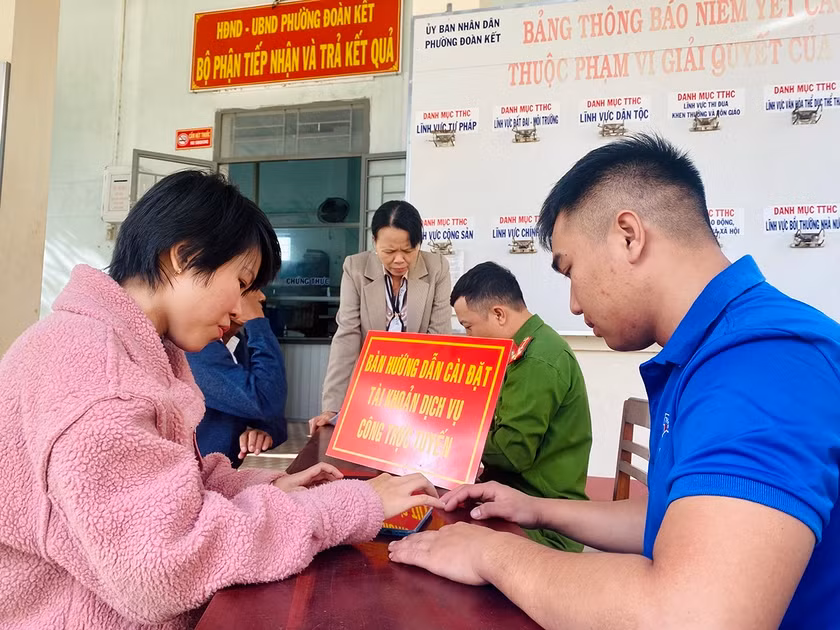Lực lượng chức năng phường Đoàn Kết (thị xã Ayun Pa) hướng dẫn người dân cài đặt tài khoản định danh điện tử VneID. Ảnh: N.S
