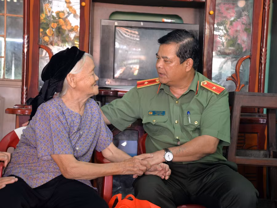 Thiếu tướng Rah Lan Lâm-Giám đốc Công an tỉnh Gia Lai ân cần hỏi thăm sức khỏe bà Hoàng Thị Nghiều (thôn Pác Bó, xã Ia Lâu) có chồng là liệt sĩ. Ảnh: L.A