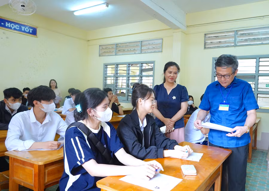 Giám đốc Sở GD-ĐT Lê Duy Định (bìa phải)-Phó Trưởng ban Thường trực Ban Chỉ đạo thi cấp tỉnh, Chủ tịch Hội đồng thi-kiểm tra công tác hướng dẫn thí sinh làm thủ tục dự thi, phổ biến quy chế thi tại điểm thi Trường THPT Pleiku. Ảnh: Mộc Trà