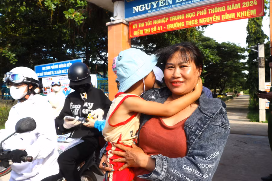 Chị Nguyễn Thị Loan (thôn Trạm Lập, xã Sơn Lang, huyện Kbang) cùng người con út đến đón con đi thi. Ảnh: Ngọc Minh