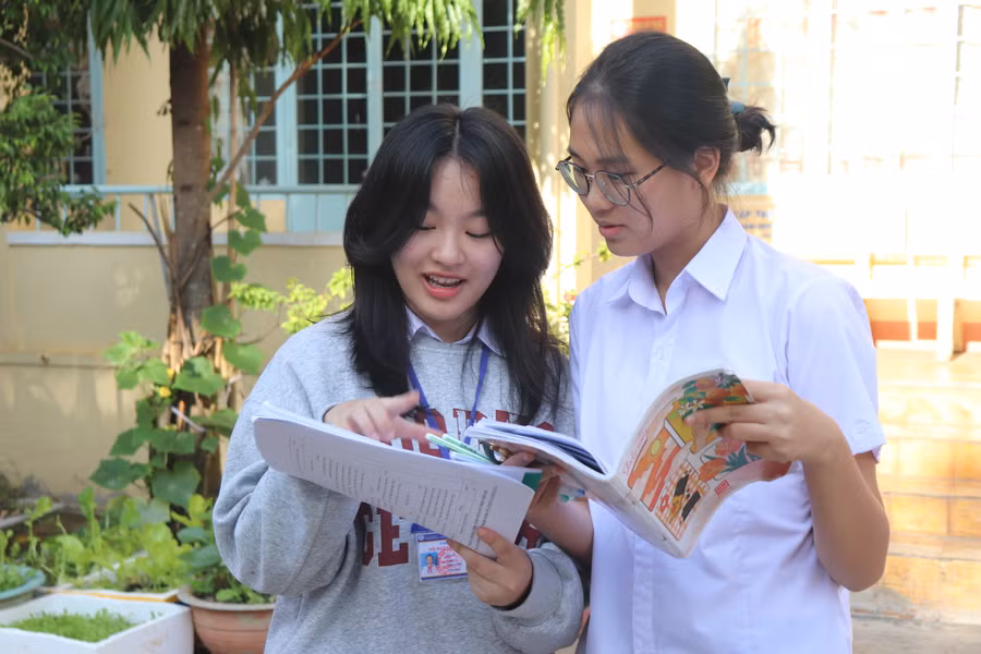 Thí sinh tranh thủ trao đổi bài cùng bạn trước khi bước vào thi môn đầu tiên. Ảnh: Lạc Hà