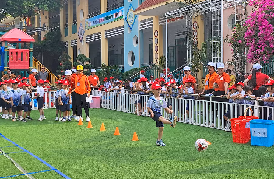 Các bé tham gia trò chơi vượt chướng ngại vật đá bóng vào khung thành. Ảnh: Mộc Trà