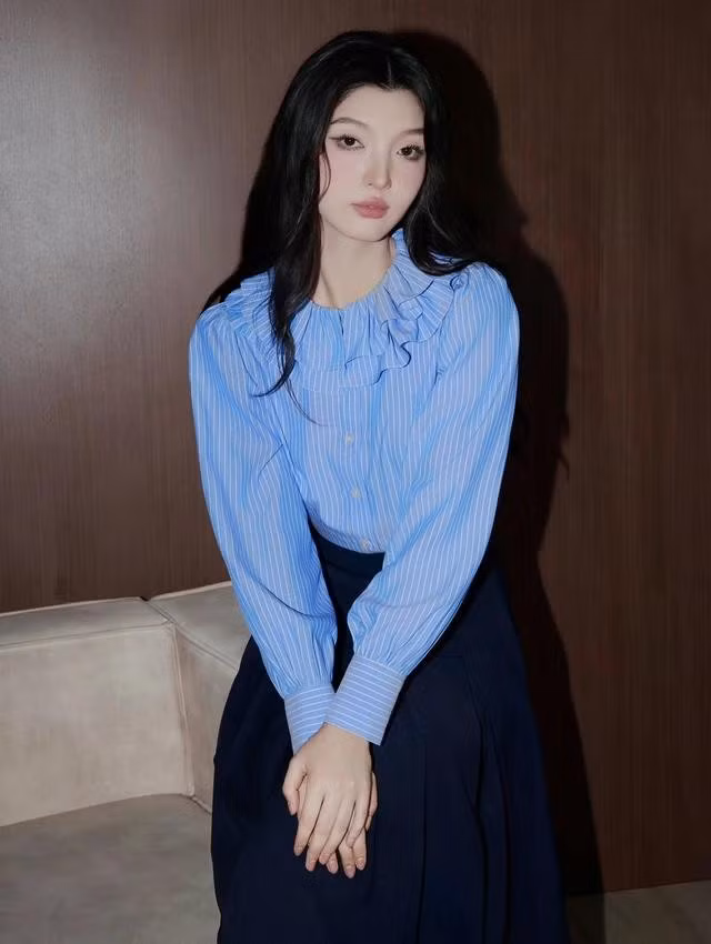 Bèo nhún xếp lớp viền cổ áo sơ mi cách điệu mang đến vẻ nữ tính và dịu dàng cho thiết kế sọc kẻ màu xanh. ẢNH: MAGNOLIA
