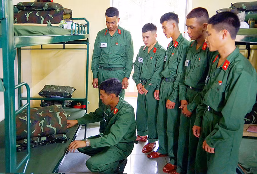 Hướng dẫn chiến sĩ mới gấp chăn màn trong những ngày đầu nhập ngũ ở Trung đoàn Thông tin 29. Ảnh: T.D