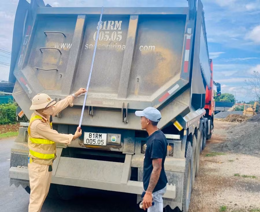 Cán bộ Đội Cảnh sát giao thông đường bộ số 1 (Phòng Cảnh sát giao thông, Công an tỉnh) đo kích thước thành thùng một xe tải lưu thông trên tuyến Quốc lộ 25. Ảnh: ĐVCC