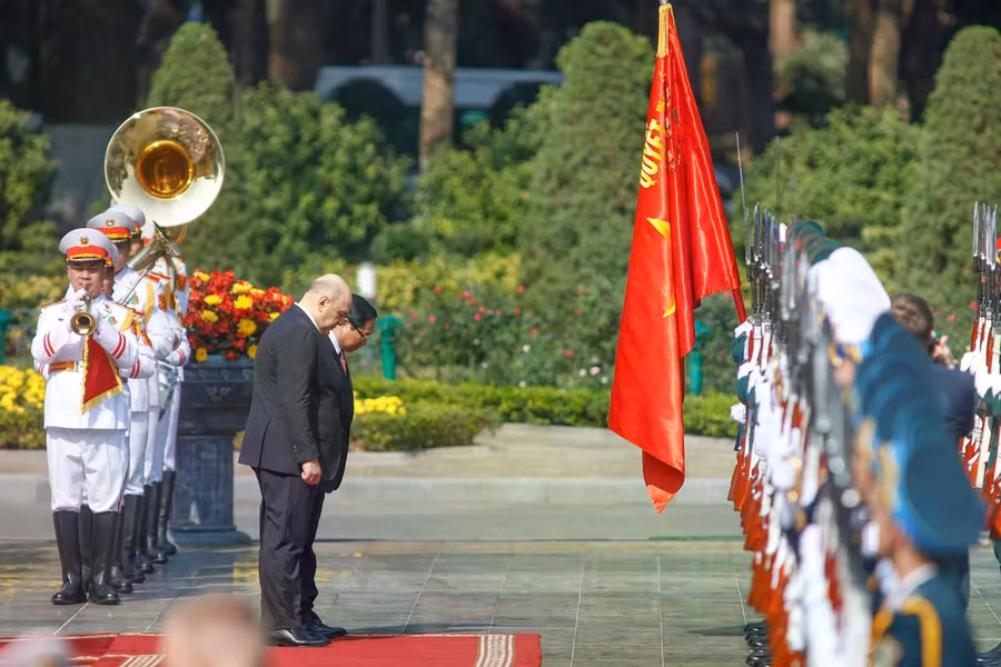 Thủ tướng Phạm Minh Chính và Thủ tướng Nga Mikhail Mishustin chào Quân kỳ quyết thắng của Quân đội nhân dân Việt Nam. ẢNH: TUẤN MINH