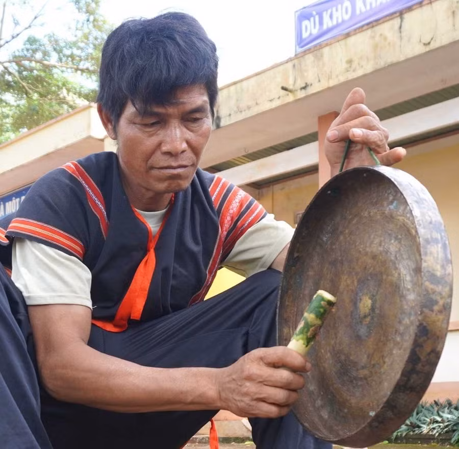 Ông Rơ Châm Kok tỉ mỉ chỉnh từng chiếc chiêng. Ảnh: Chu Hằng