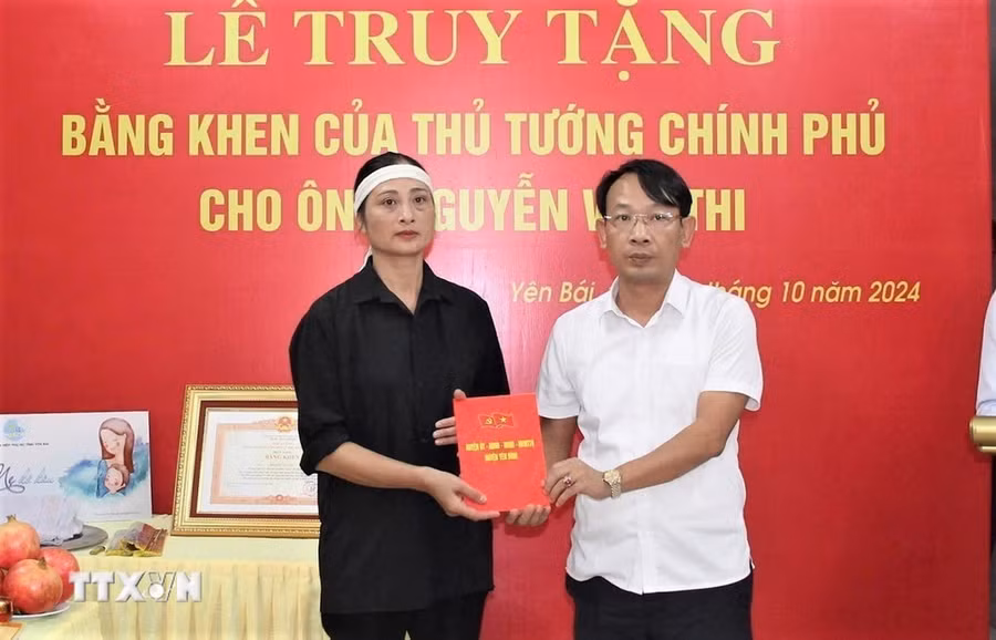 Các cơ quan, đơn vị tặng quà, hỗ trợ cho đại diện gia đình ông Nguyễn Văn Thi. (Ảnh: TTXVN phát)