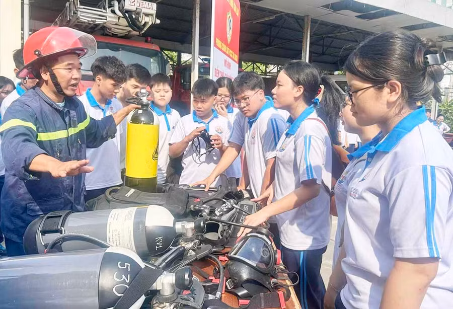 Các em học sinh được nghe giới thiệu về tính năng của bình khí dùng khi cứu nạn. Ảnh: K.A
