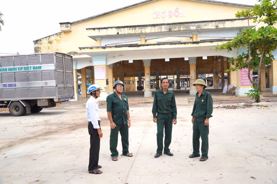 Cựu chiến binh Lưu Văn Nhơn (ngoài cùng bên phải) tham gia bảo vệ an ninh trật tự trước cổng chợ Đồn (phường An Nhơn Nam). Ảnh: Gia Nguyễn