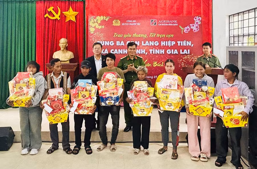 Cán bộ Công an xã Tuy Phước Tây trao quà Tết cho người dân làng Hiệp Tiến, xã Canh Vinh. Ảnh: K.A