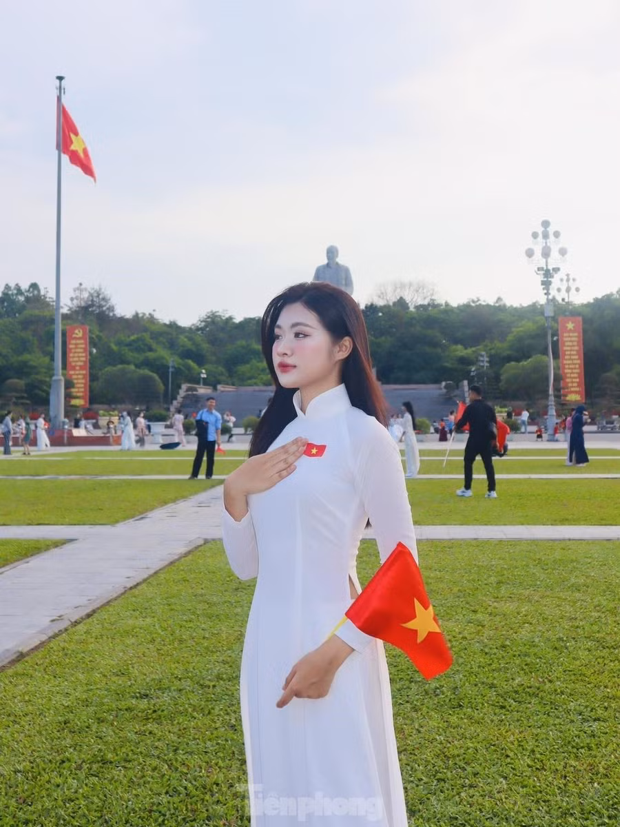 Các bạn trẻ trong tà áo dài nền nã, tay cầm lá cờ Tổ quốc, cùng nhau lưu giữ khoảnh khắc kỷ niệm.