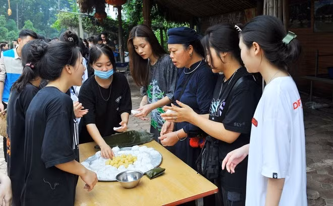 Du khách trải nghiệm cách làm bánh với người dân địa phương. (Ảnh: TTXVN)