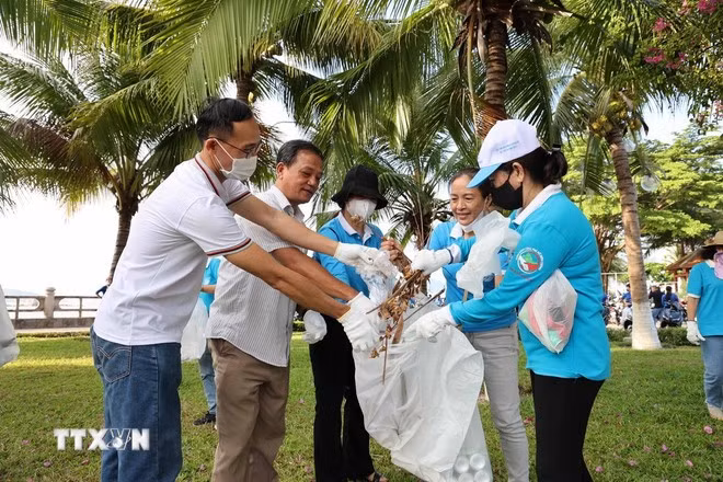 Người dân thành phố Nha Trang nhặt rác ven bãi biển. (Ảnh: Đặng Tuấn/TTXVN)