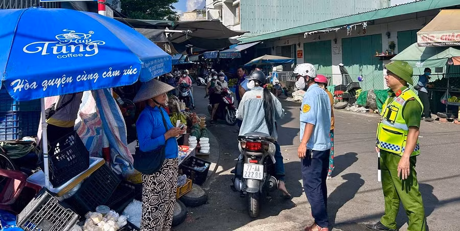 Công an xã Tuy Phước tuyên truyền, cho các hộ kinh doanh dọc tuyến Quốc lộ 1 ký cam kết không lấn chiếm vỉa hè, lòng lề đường để buôn bán. Ảnh: K.A