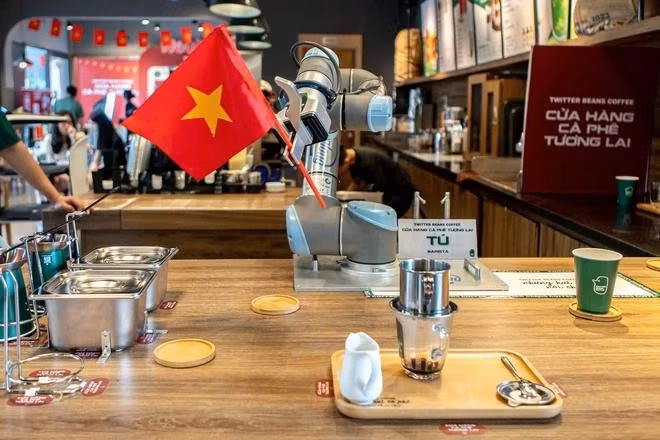 Robot thực hiện các thao tác như đổ nước nóng, pha cà phê... Sau khi pha chế xong, robot vẫy cờ thông báo cho khách hàng. ẢNH: MINH NHÂN