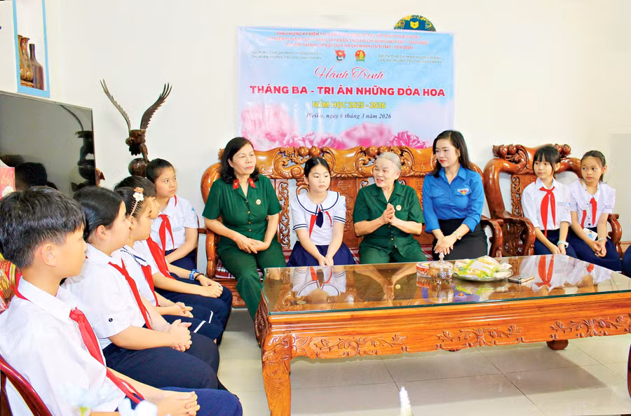 Liên đội Trường Tiểu học Chu Văn An (phường Pleiku) thăm, nghe nữ du kích Huỳnh Thị Tuyết Sương (thứ 4 từ phải qua) chia sẻ về quá trình tham gia cách mạng.