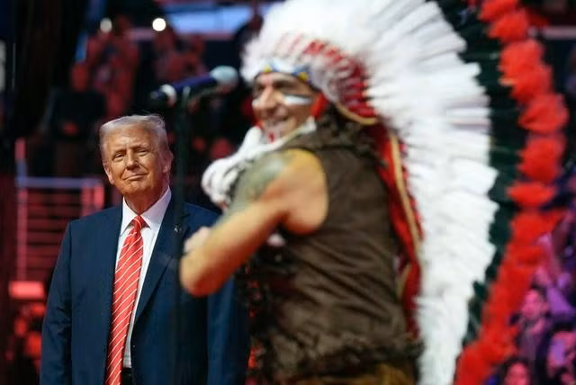 Ông Trump và thành viên nhóm biểu diễn Village People trong sự kiện mít tinh ở nhà thi đấu Capitol One hôm 19.1. Ảnh: AP