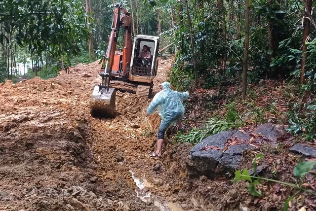 UBND xã Phước Gia đưa xe múc mở kênh dẫn nước để hạn chế nước mưa chảy trực tiếp vào khu vực vết nứt trên quả đồi
