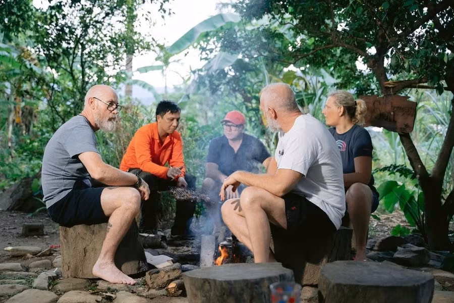 Du khách quốc tế thư giãn quanh bếp lửa hồng ở bản Rum Ho (Quảng Bình). (Ảnh: Mạnh Thành/TTXVN)