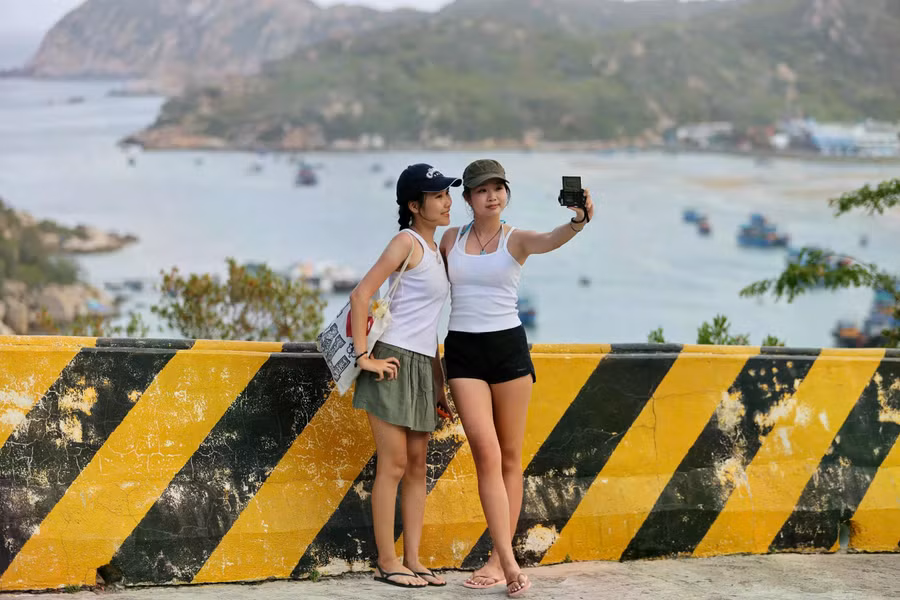 Khách du lịch lưu lại kỷ niệm trên con đường ven biển Ninh Thuận. Phía sau là vịnh Vĩnh Hy, một trong những vịnh đẹp nhất nước. ẢNH: BÁ DUY
