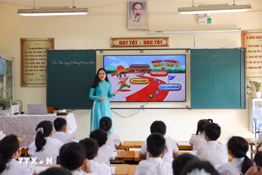 Cô giáo Hà Linh Hương, giáo viên Trường Tiểu học Thịnh Liệt (quận Hoàng Mai) tự thiết kế trang web với một kho học liệu bao gồm hơn 200 câu hỏi với nhiều hình thức làm bài góp phần thu hút học sinh hămg say học tập. (Ảnh: Thanh Tùng/TTXVN)