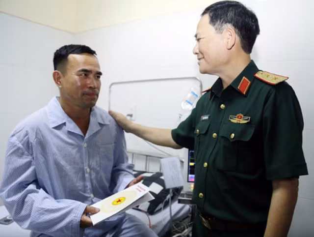 Trung tướng Phạm Trường Sơn, Phó Tổng Tham mưu trưởng Quân đội nhân dân Việt Nam, trao quà cho phi công Nguyễn Văn Sơn. Ảnh: NLĐO