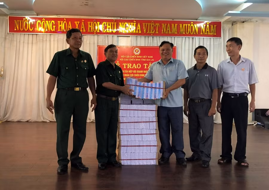 Chủ tịch Hội Cựu chiến binh tỉnh Nay Hứ (thứ 2 từ trái sang) trao tập vở cho đại diện Hội Cựu chiến binh các huyện. Ảnh: Anh Huy