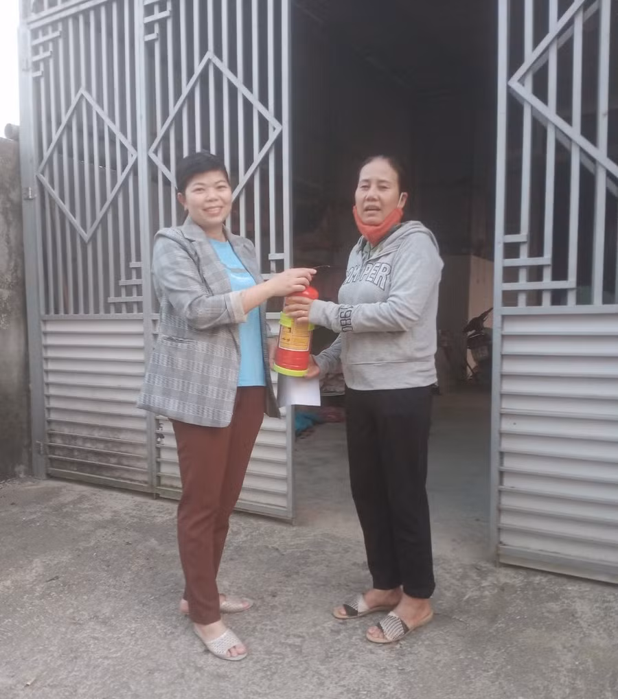 Chị Lợi (bên trái) tuyên truyền, vận động người dân trang bị bình chữa cháy. Ảnh: P.D