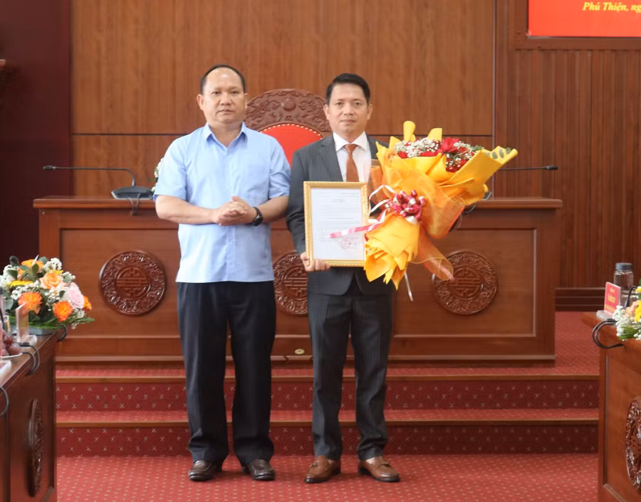 Phó Bí thư Tỉnh ủy Rah Lan Chung (bên trái) trao quyết định và tặng hoa chúc mừng tân Bí thư Huyện ủy Phú Thiện. Ảnh: P.D