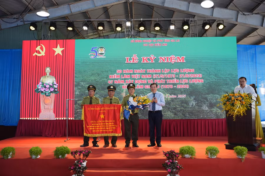Chủ tịch UBND tỉnh Trương Hải Long tặng Cờ "Vì sự nghiệp xây dựng và bảo vệ tỉnh Gia Lai'' cho Chi cục Kiểm lâm tỉnh. Ảnh: Nguyễn Diệp