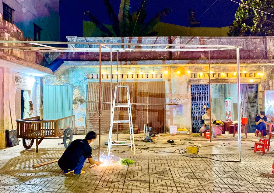Các hộ kinh doanh may mắn mượn được mặt bằng nhà hàng Ngọc Lâm đang khẩn trương làm mái che để đưa hoạt động mua bán trở lại. Ảnh: Hà Duy