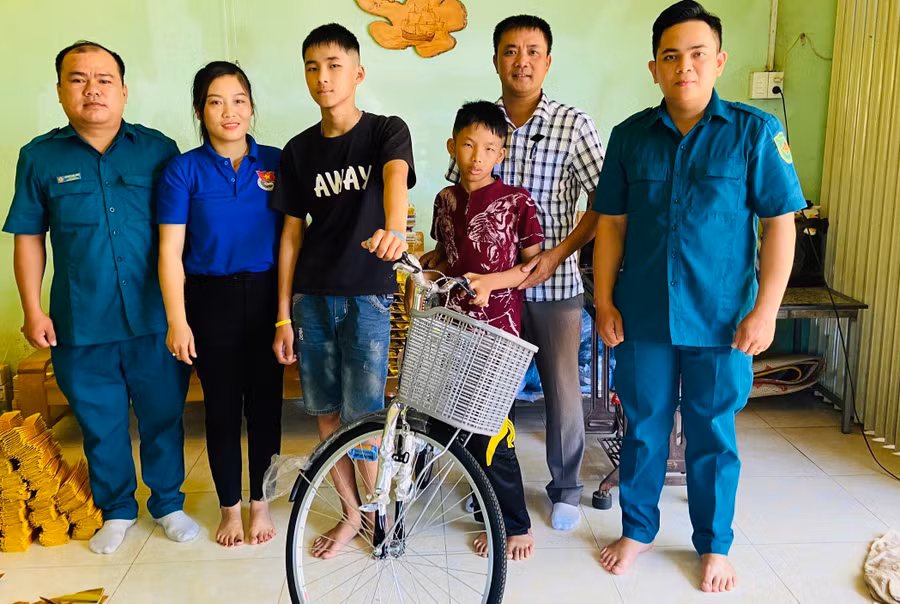 Anh Mão (ngoài cùng bìa trái) cùng lãnh đạo phường Phù Đổng tặng xe đạp cho gia đình chị Nguyễn Thị Bích Nga. Ảnh: T.D