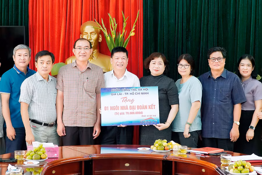 Đại diện nhóm công tác xã hội trao bảng tượng trưng tặng nhà "Đại đoàn kết" cho Ban Dân vận Tỉnh ủy. Ảnh: Đức Thụy
