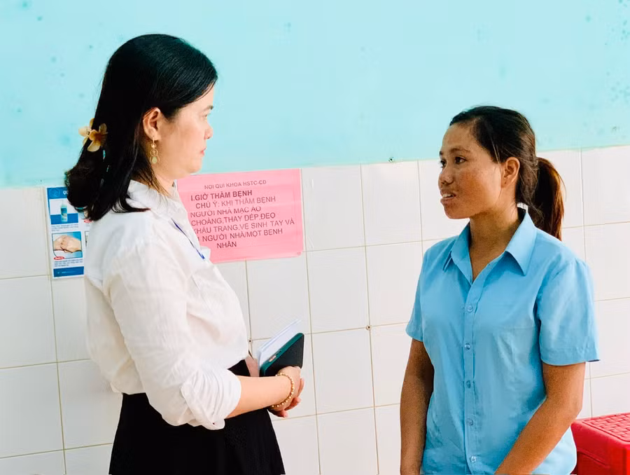Chị Nguyễn Thị Nga-Phòng Công tác xã hội (Bệnh viện đa khoa tỉnh) thăm hỏi, động viên chị Kpuih Aven (vợ bệnh nhân Lương Văn Khanh). Ảnh: Như Nguyện