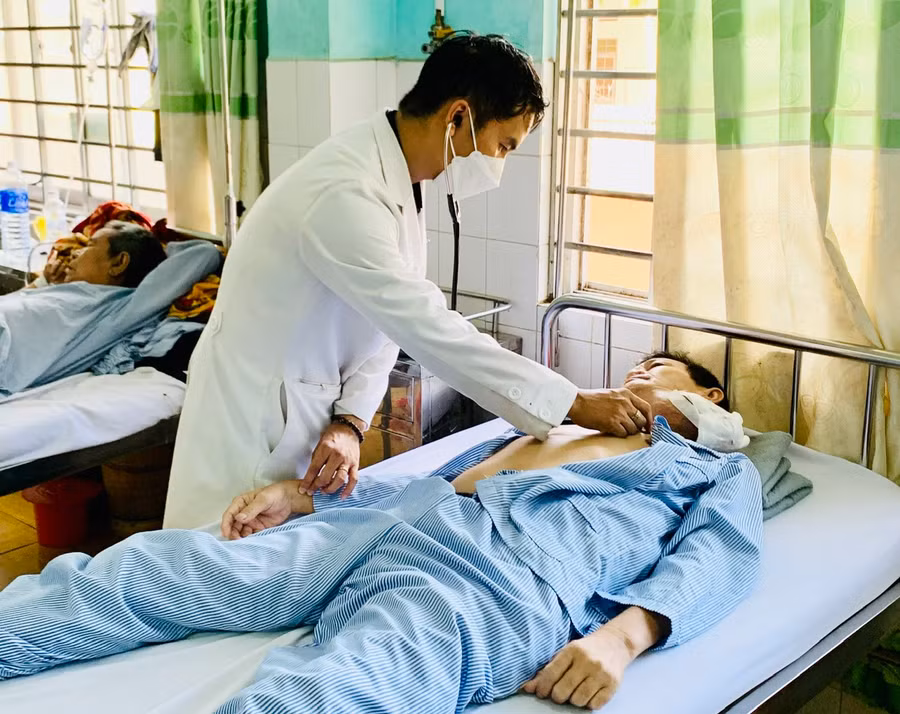 Bác sĩ Nguyễn Đình Hùng thăm khám và điều trị cho bệnh nhân tại Khoa Ung bướu và Y học hạt nhân. Ảnh: Như Nguyện
