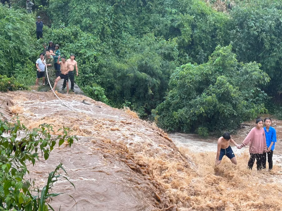 Ba cháu bé bị mắc kẹt giữa dòng nước chảy xiết. Ảnh: Đ.N