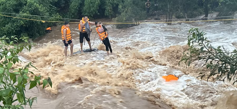 Lực lượng cứu hộ đã giăng dây cố gắng để tiếp cận và đưa các cháu bé vào bờ an toàn. Ảnh: Đ.N