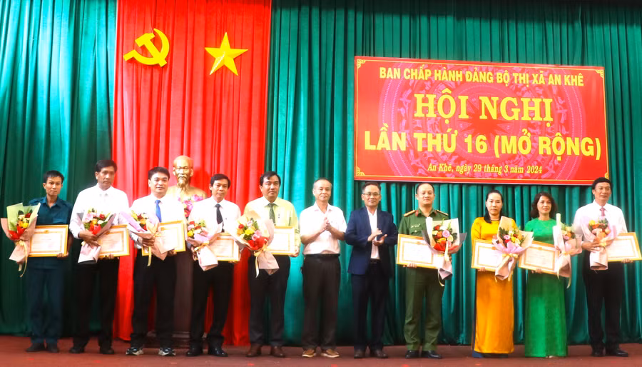 Bí thư Thị ủy An Khê Nguyễn Xuân Phước (thứ 5 bên phải) và Phó Bí thư Thường trực Thị ủy, Chủ tịch HĐND thị xã An Khê Nguyễn Hùng Vỹ (thứ 6 bên phải) trao giấy khen cho các tập thể. Ảnh: Ngọc Minh
