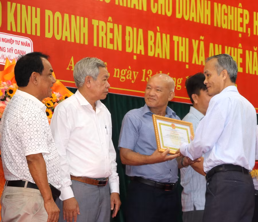 Phó Bí thư Thị ủy, Chủ tịch UBND thị xã An Khê Nguyễn Hùng Vỹ (bìa phải) tặng giấy khen cho tập thể, hộ kinh doanh. Ảnh: Ngọc Minh