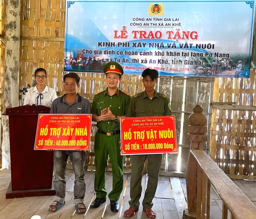 Thượng tá Nguyễn Thành Huy-Trưởng Công an thị xã An Khê tặng kinh phí và vật nuôi cho gia đình có hoàn cảnh khó khăn ở làng Pơ Nang, xã Tú An. Ảnh: Ngọc Minh