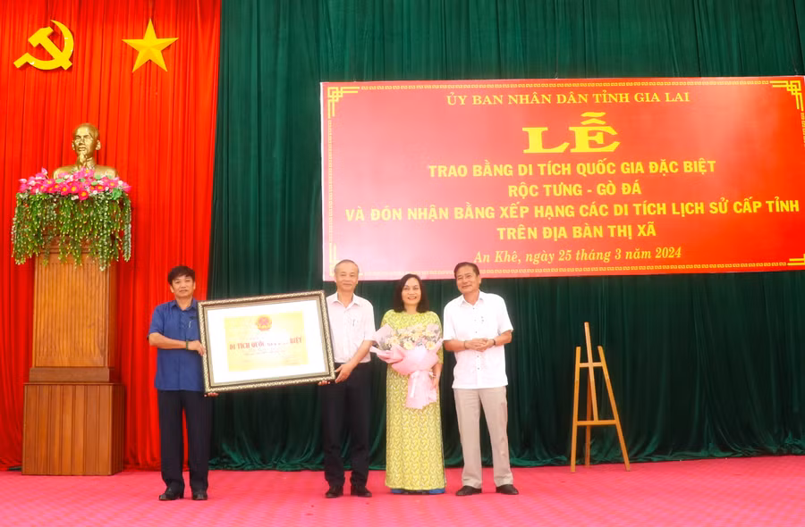 Ông Trần Ngọc Nhung (bìa phải)-Giám đốc Sở Văn hóa-Thể thao và Du lịch tỉnh, Phó Trưởng ban Quản lý di tích quốc gia đặc biệt tỉnh Gia Lai trao lại bằng xếp hạng di tích quốc gia đặc biệt Rộc Tưng-Gò Đá cho thị xã An Khê. Ảnh: Ngọc Minh