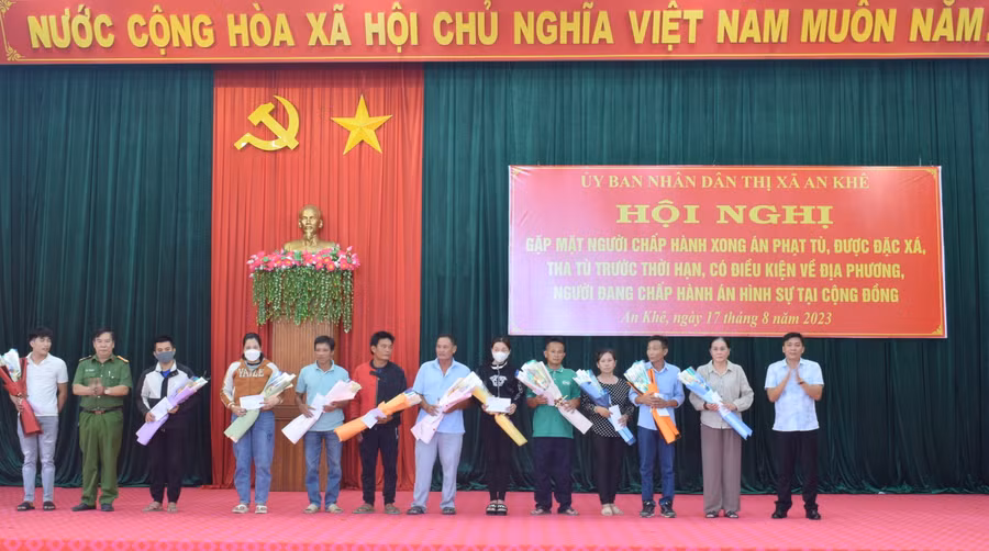Đại diện lãnh đạo thị xã An Khê, Công an thị xã An Khê tặng hoa và quà những người tái hòa nhập cộng đồng có hoàn cảnh khó khăn. Ảnh: An Phát