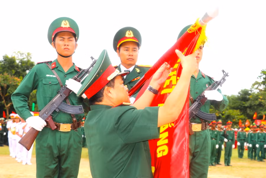 Trung tướng Trịnh Đình Thạch-Bí thư Đảng ủy, Chính ủy Quân khu 5 gắn Huân chương Bảo vệ Tổ quốc hạng Ba lên Quân kỳ Quyết thắng của Trung đoàn 38. Ảnh: Ngọc Minh