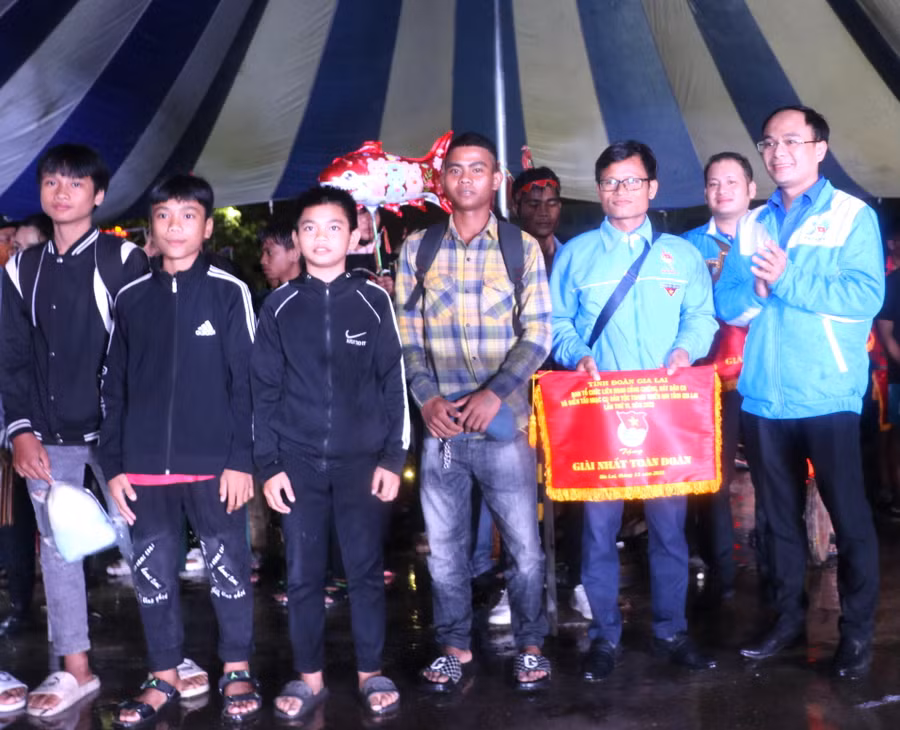 Anh Đỗ Đức Thanh-Phó Bí thư Tỉnh đoàn, Chủ tịch Hội Liên hiệp thanh niên Việt Nam tỉnh Gia Lai, Trưởng Ban Tổ chức Liên hoan (bìa phải) trao giải nhất toàn đoàn cho đội thi huyện Kbang. Ảnh: Ngọc Minh