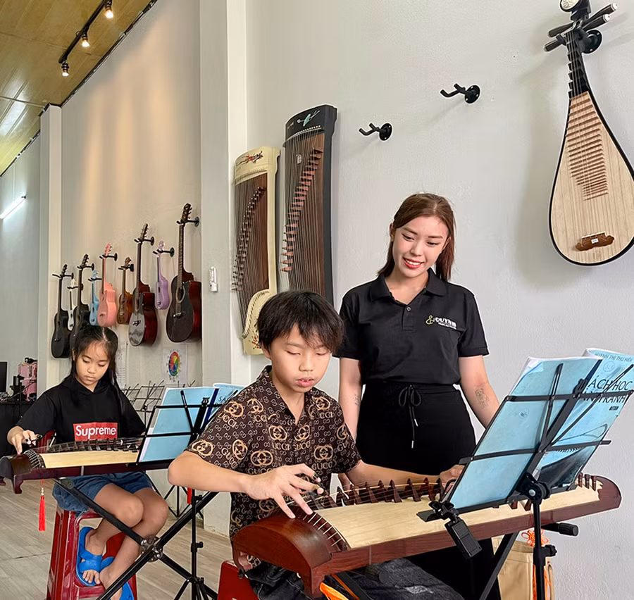 Chị Hồ Thị Như Quỳnh hướng dẫn học viên tập đánh đàn tranh. Ảnh: L.N