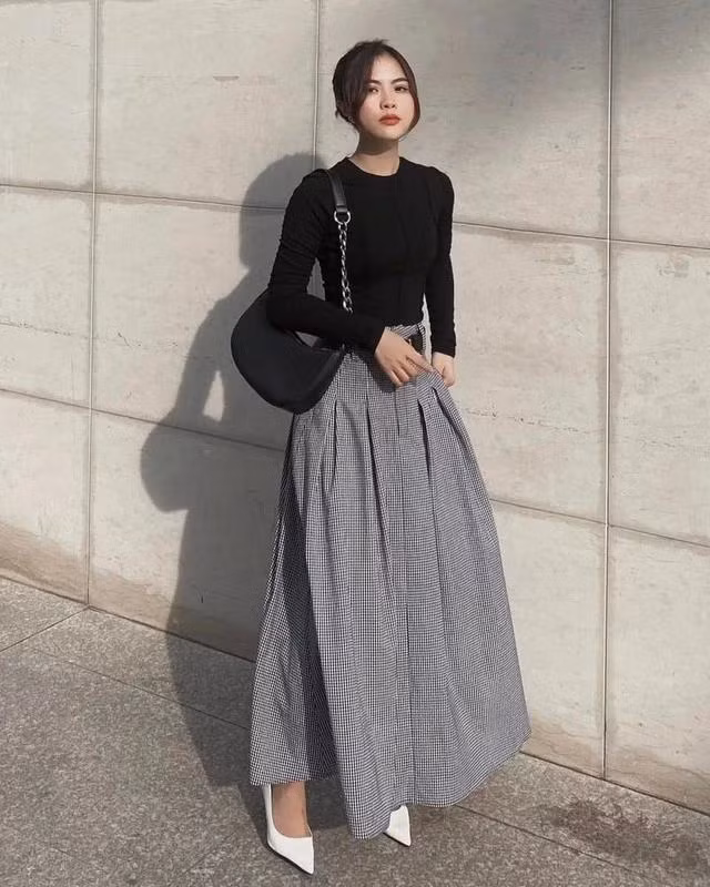 Sự hòa quyện của những gam màu trung tính, giản đơn nhưng vẫn vô cùng cuốn hút, ấn tượng. Thiết kế chân váy dài thanh lịch họa tiết ca rô truyền thống có thể tạo ra nhiều bản phối khác nhau, phù hợp cho môi trường công sở, những buổi dạo phố và cả những buổi hẹn hò lãng mạn. Ảnh Charmo